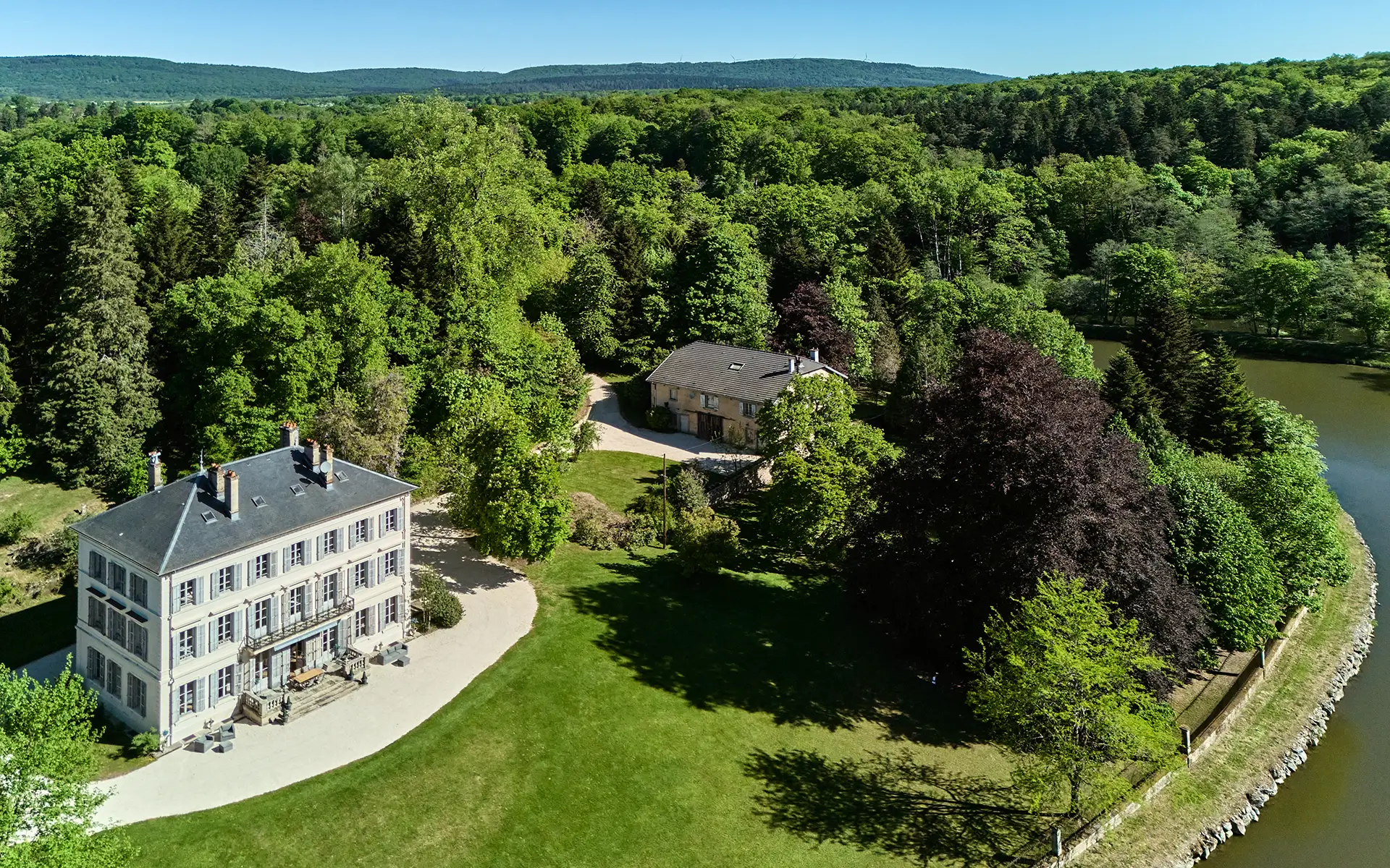 Vue de la propriété de la entre canal et forêt : le château de Freland à vendre - Arrière-Cour, agence immobilière spécialisée en Haute-Saône
