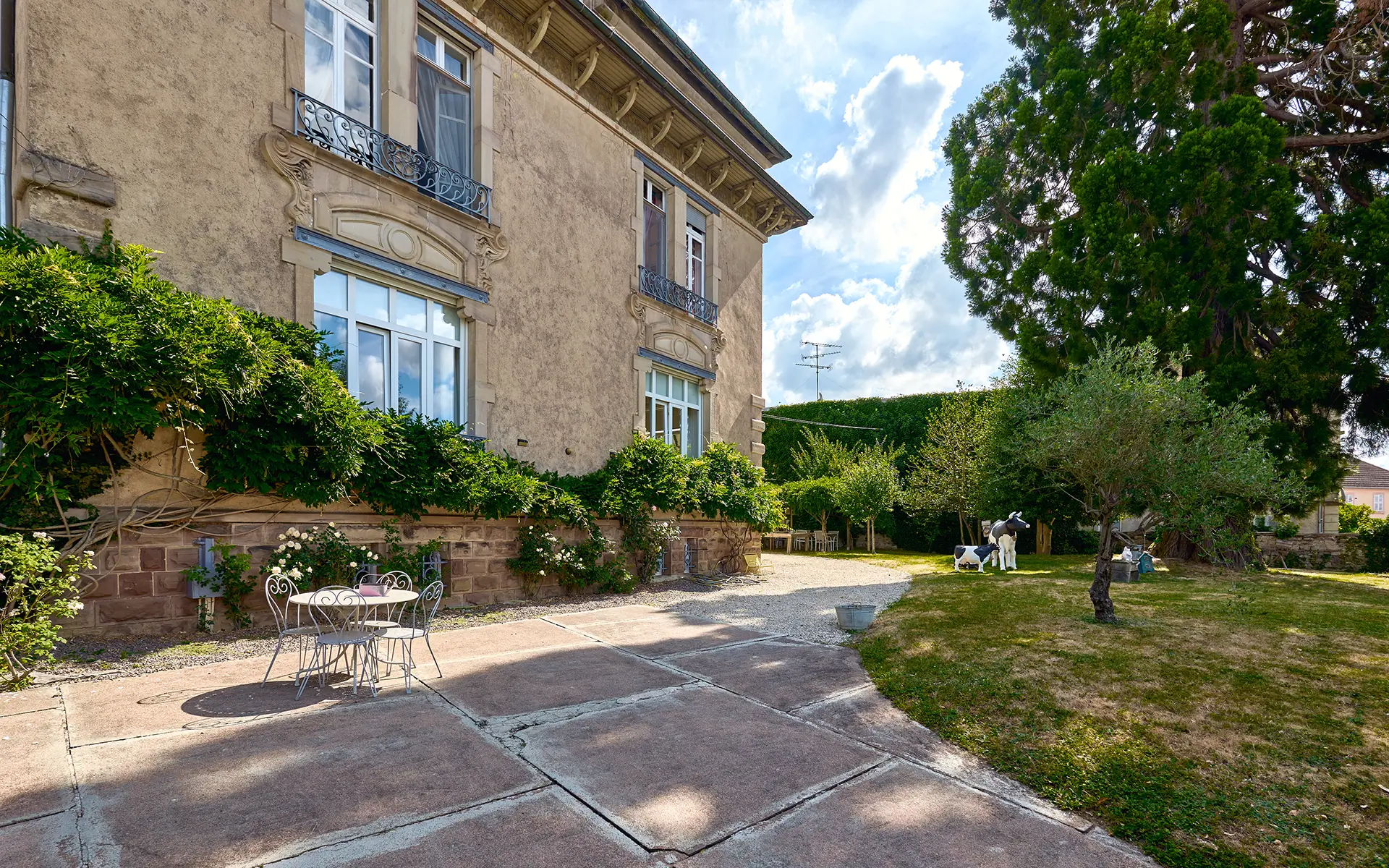 Façade et terrasse d'une demeure de caractère à Luxeuil-les-Bains à vendre - Arrière-Cour, agence immobilière spécialisée en Haute-Saône
