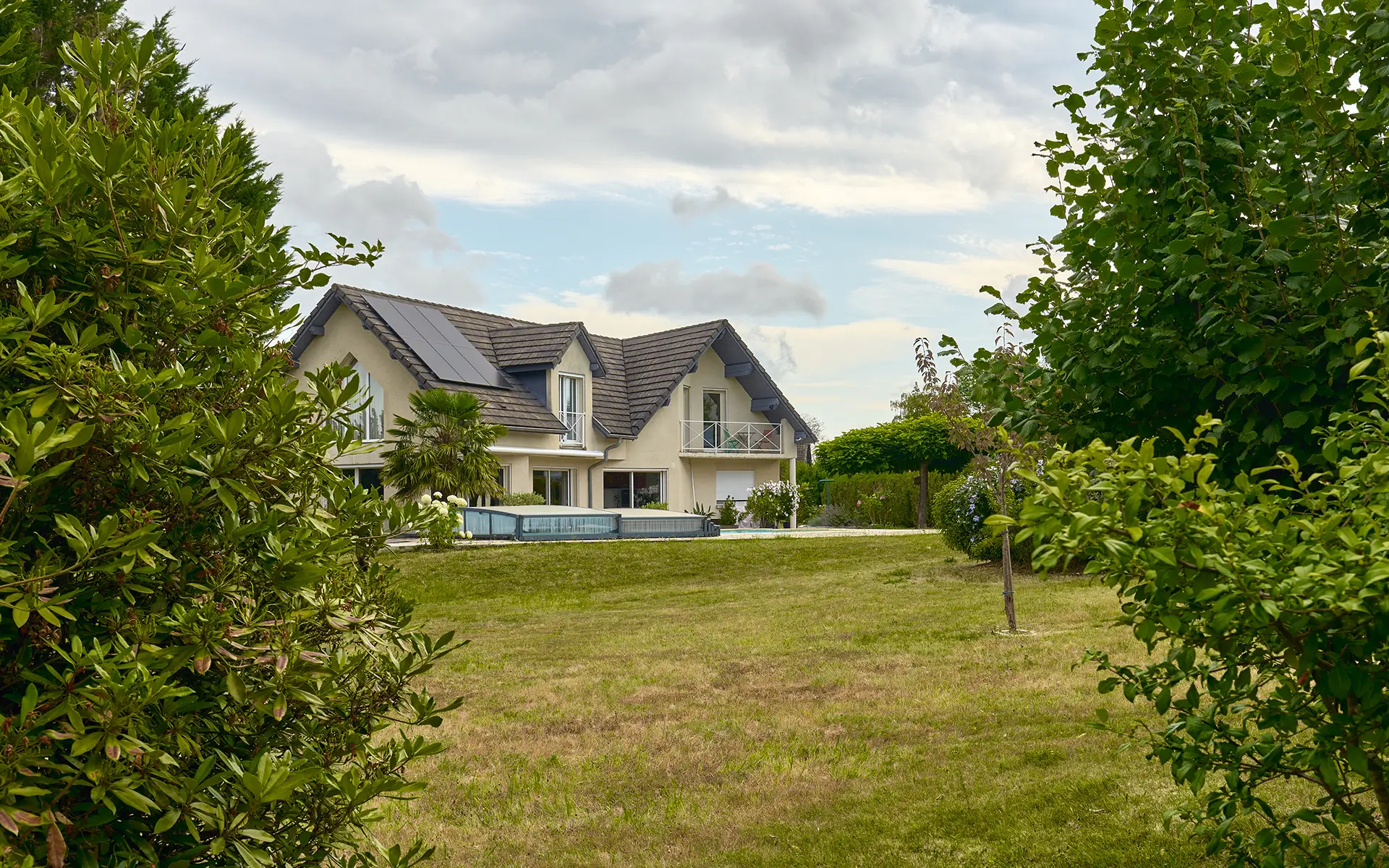 Façade lumineuse d'une maison familiale avec piscine à Besançon à vendre - Arrière-Cour, agence immobilière spécialisée dans le Doubs