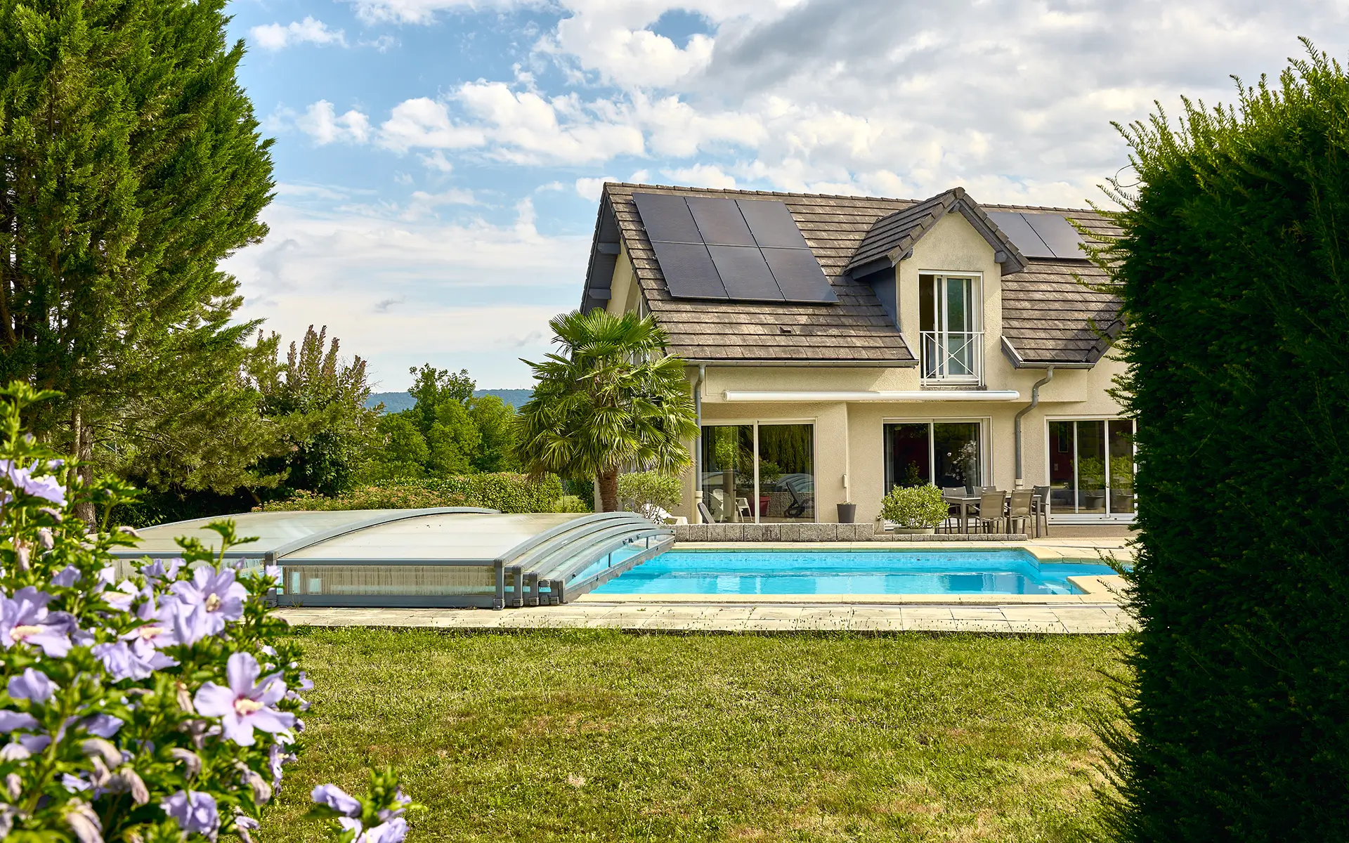 Façade et piscine d'une maison familiale avec piscine à Besançon à vendre - Arrière-Cour, agence immobilière spécialisée dans le Doubs
