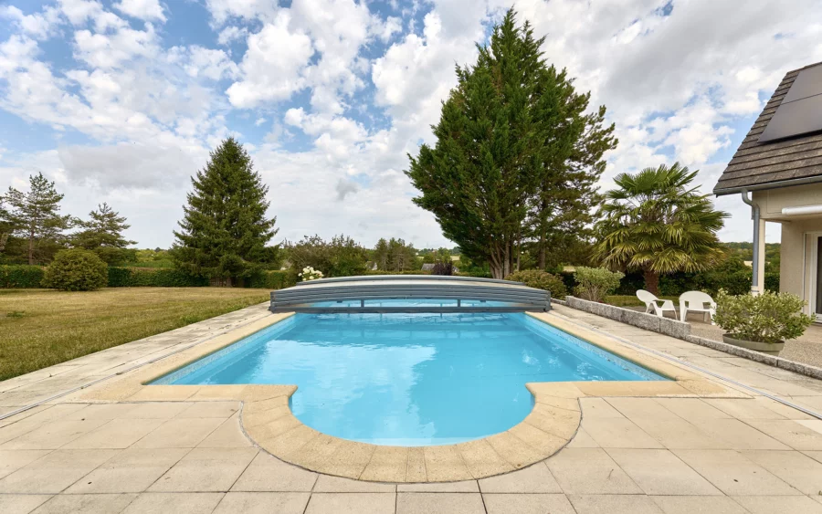 Piscine et terrasse d'une maison familiale avec piscine à Besançon à vendre - Arrière-Cour, agence immobilière spécialisée dans le Doubs