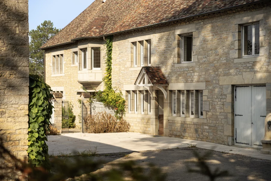 Façade en pierre de la maison de maître dans un parc arboré à Besançon à vendre - Arrière-Cour, agence immobilière spécialisée dans le Doubs
