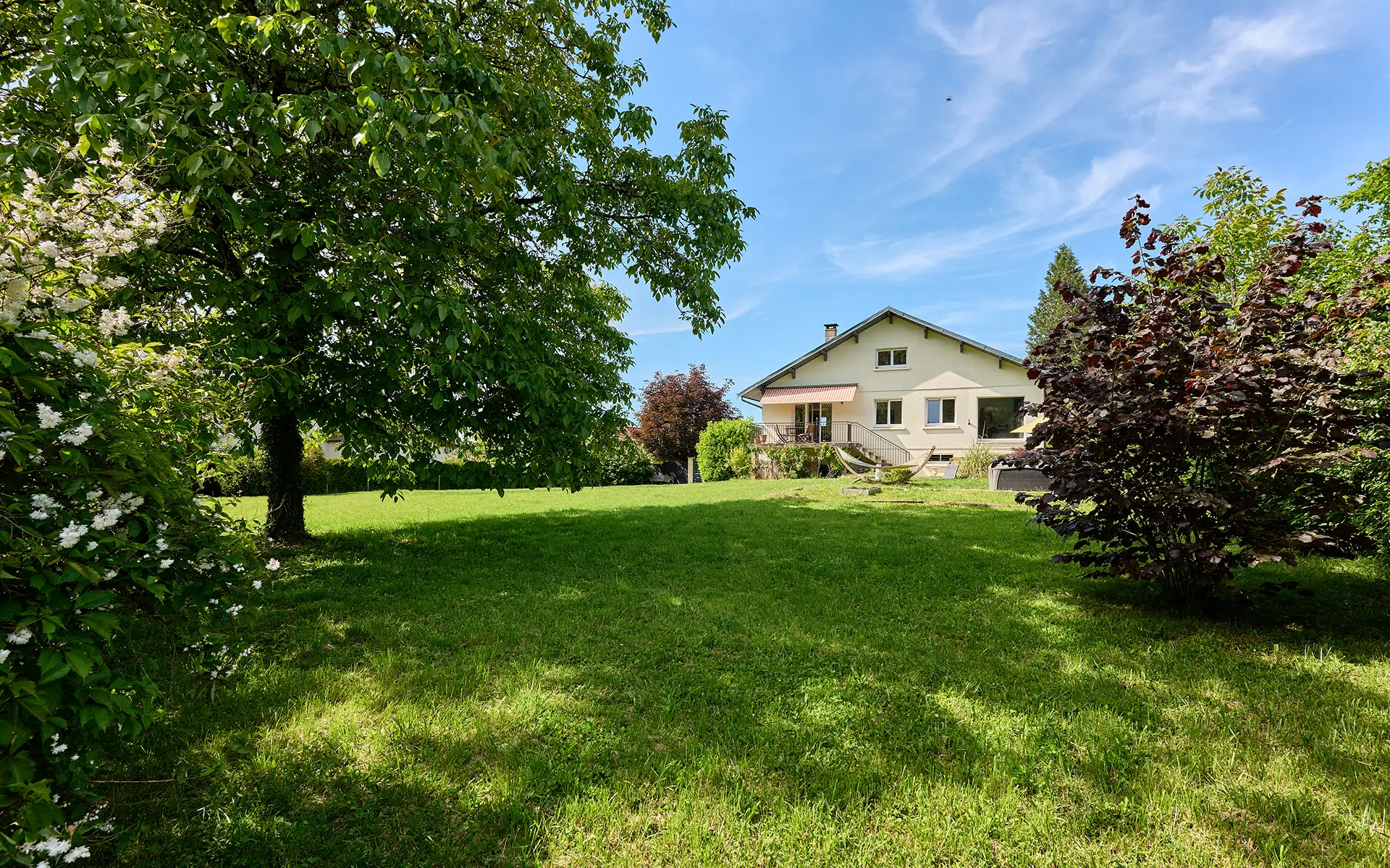 Façade et verdure de la maison contemporaine aux portes de Besançon à vendre - Arrière-Cour, agence immobilière spécialisée dans le Doubs