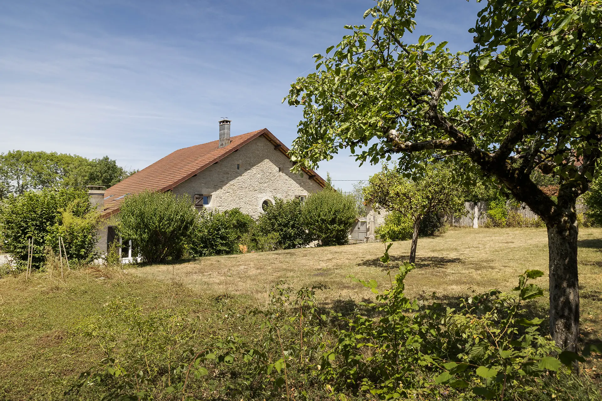 Façade lumineuse de l'ancienne ferme rénovée aux portes d'Ornans à vendre - Arrière-Cour, agence immobilière spécialisée dans le Doubs