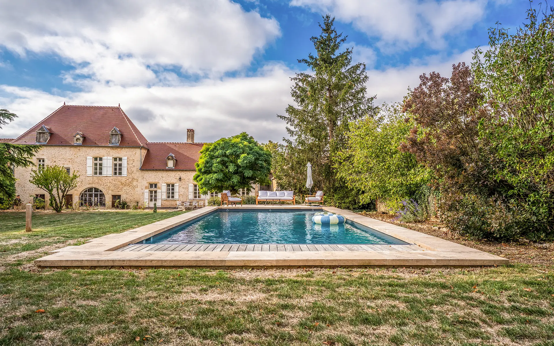 Façade et piscine du manoir du XVIᵉ siècle en Bourgogne à vendre - Arrière-Cour, agence immobilière spécialisée en Bourgogne