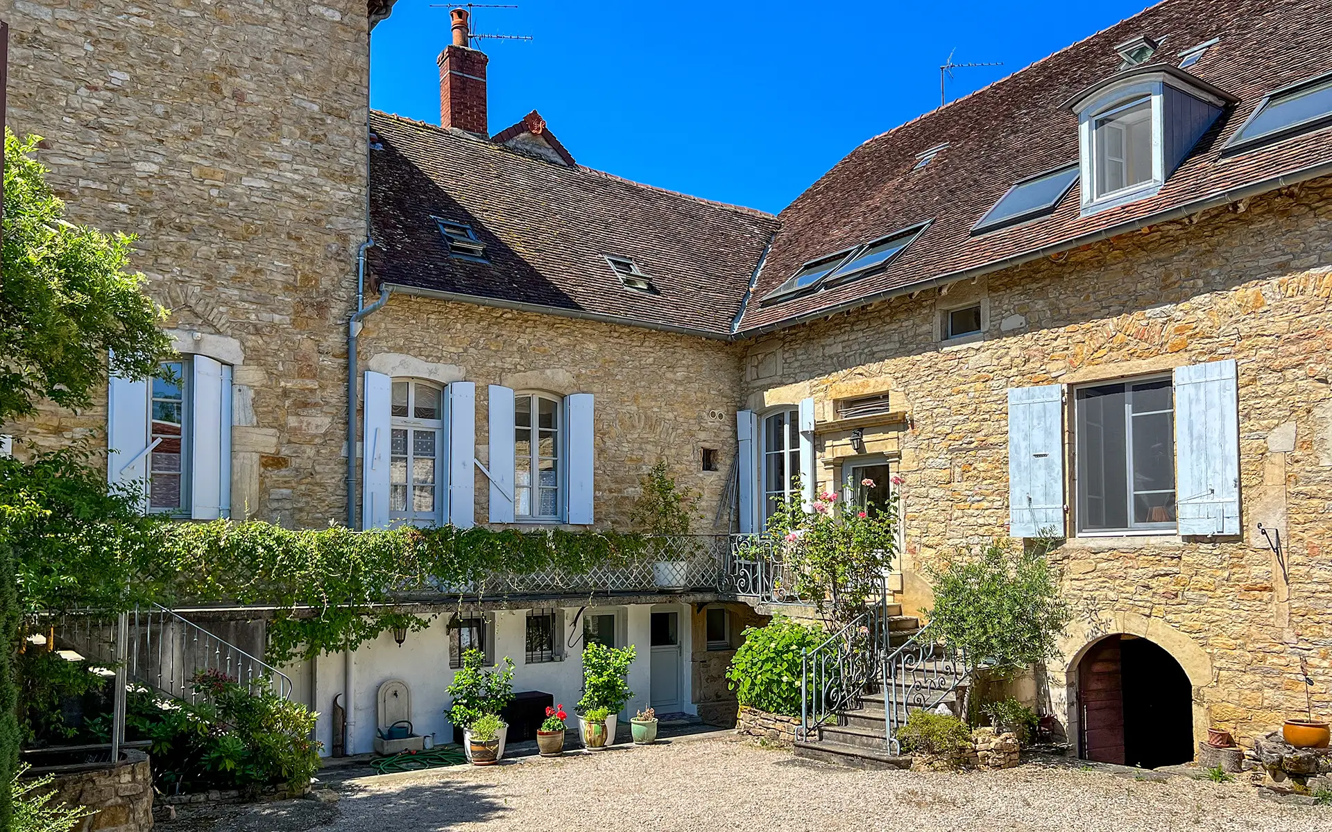 Façade d'une belle demeure du XVIIIe siècle au cœur d’un village Jurassien à vendre - Arrière-Cour, agence immobilière spécialisée dans le Jura