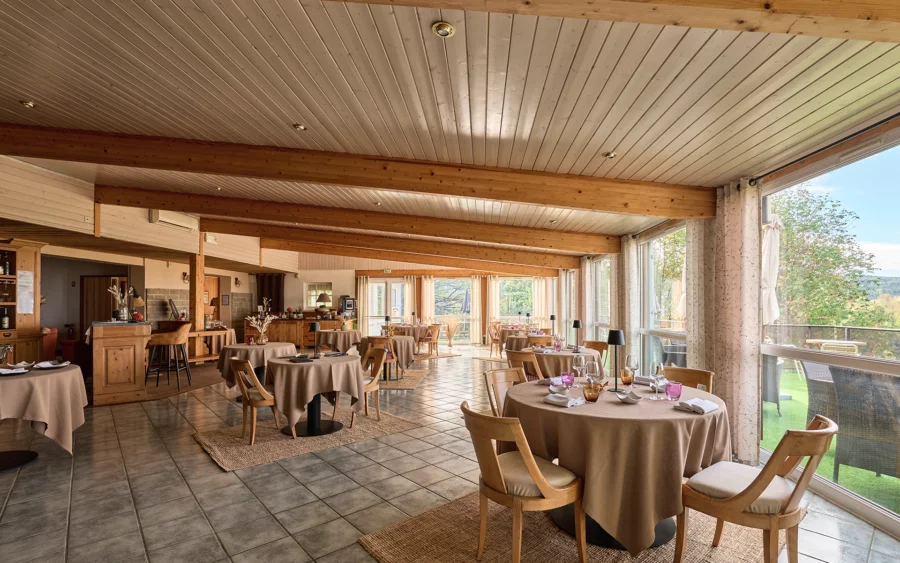 Salle à manger de l'hôtel ouvert sur les forêts du Jura à vendre - Arrière-Cour, agence immobilière spécialisée dans le Jura