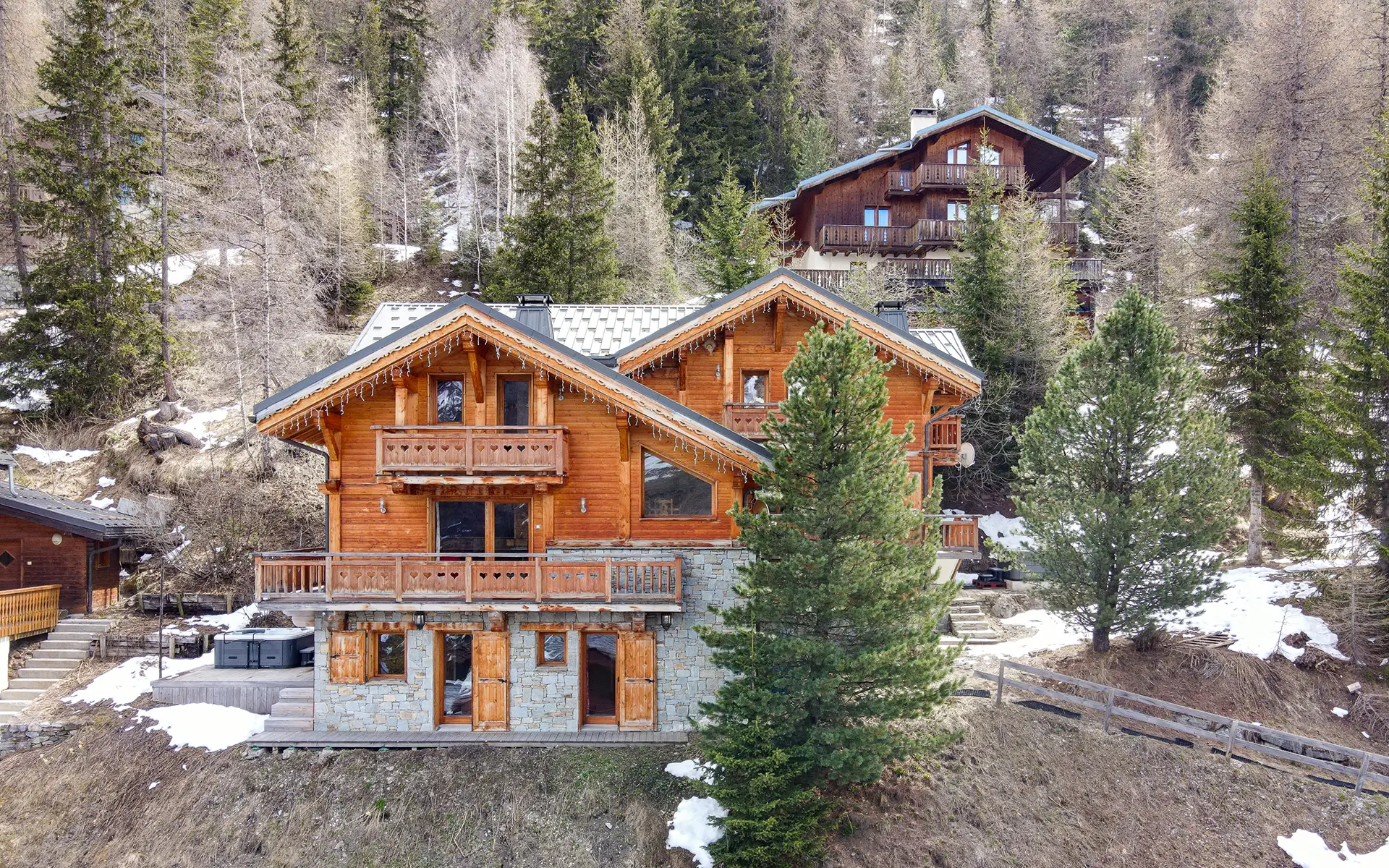 Chalet en bois entouré de neige et de forêt en montagne