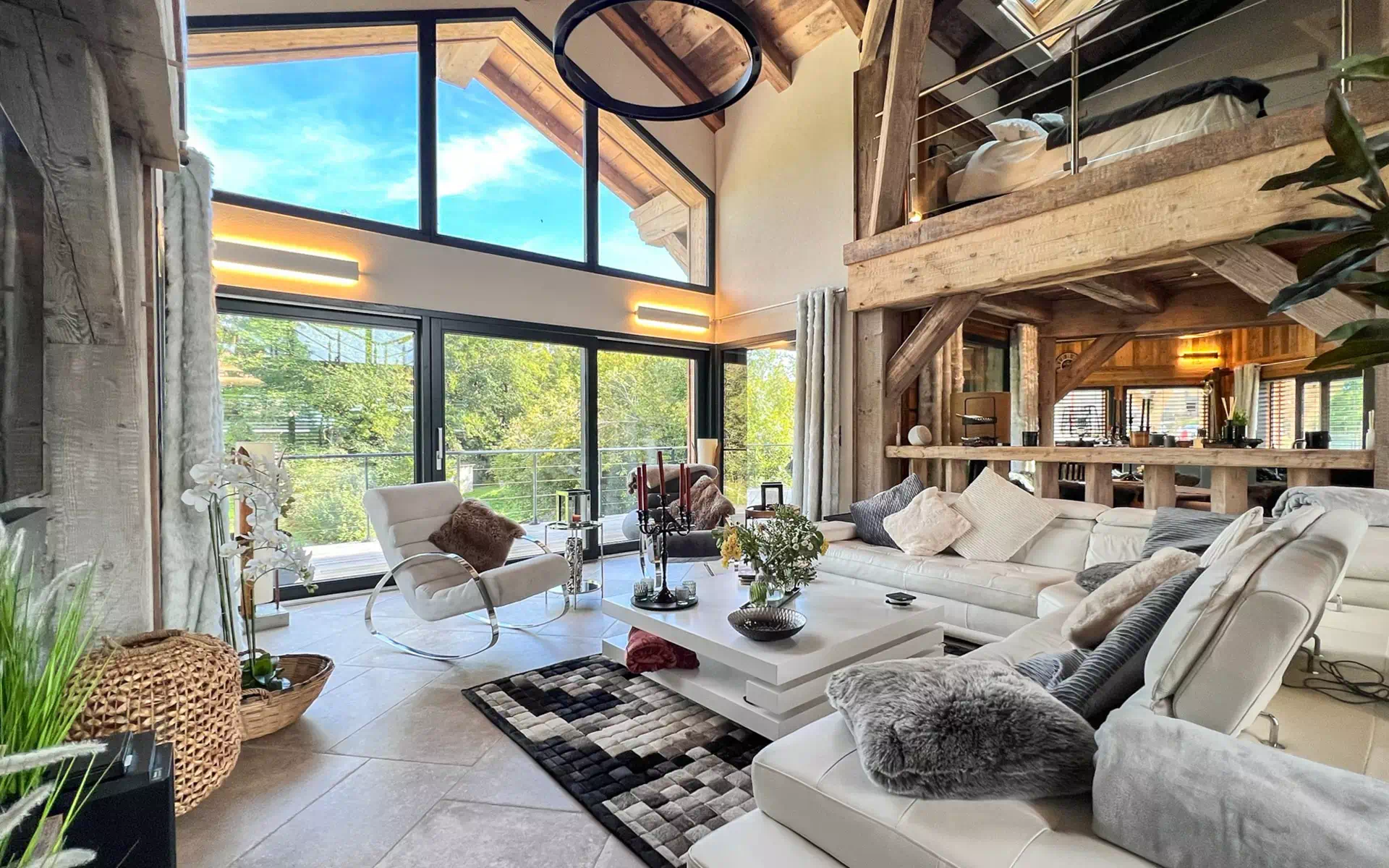 Séjour contemporain d’un chalet rénové avec charpente apparente et grandes baies vitrées