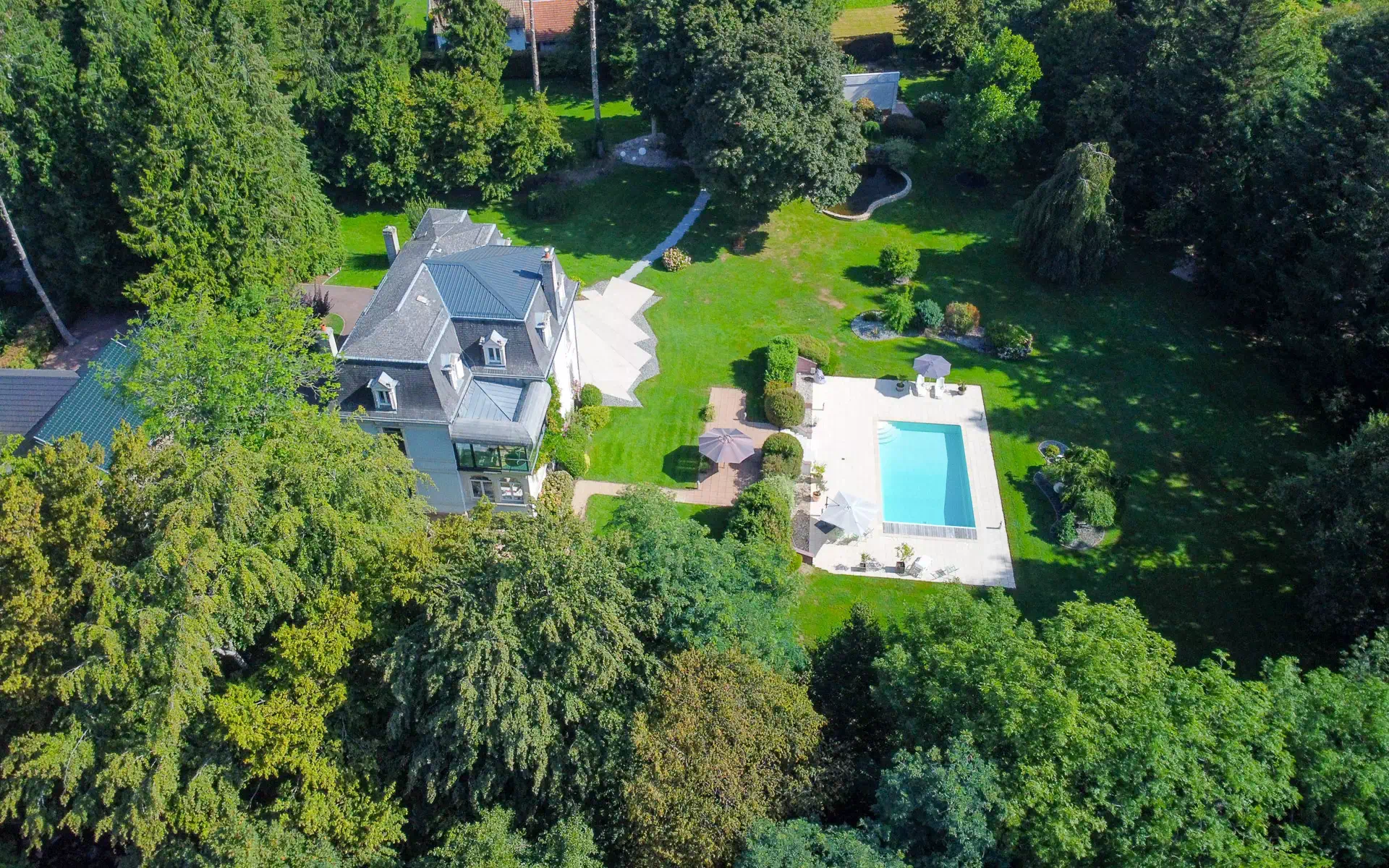 Vue aérienne d’une propriété de caractère avec parc et piscine