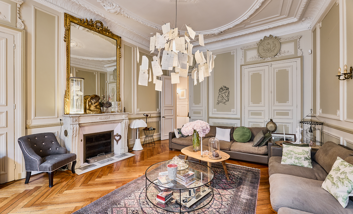 Salon d’une demeure de caractère avec moulures, cheminée en marbre et parquet ancien