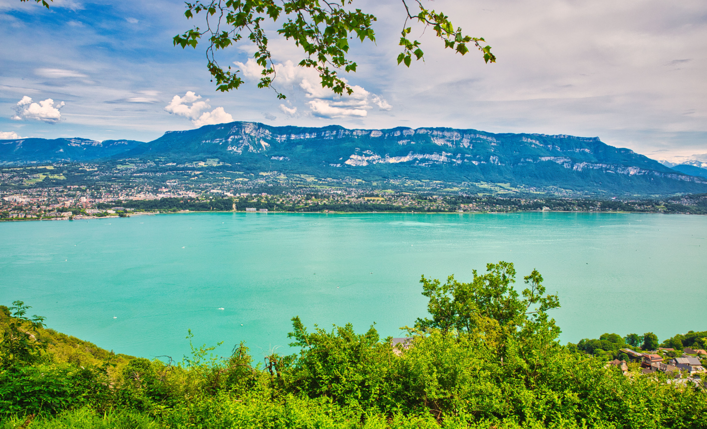 Lac alpin entouré de montagnes et de villages en Savoie