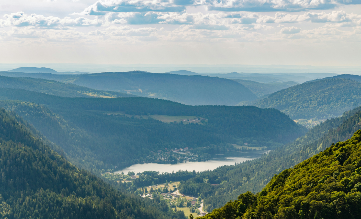 Panorama sur un lac et les reliefs boisés du massif des Vosges