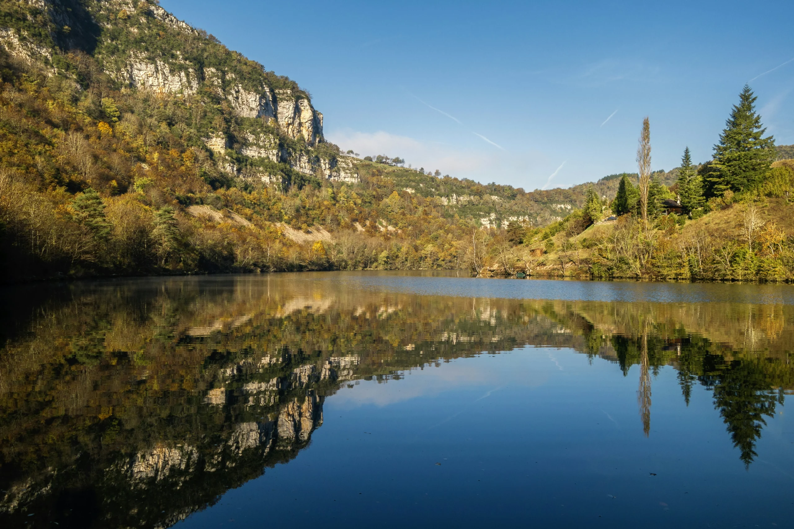 Lac entouré de reliefs boisés dans l’Ain