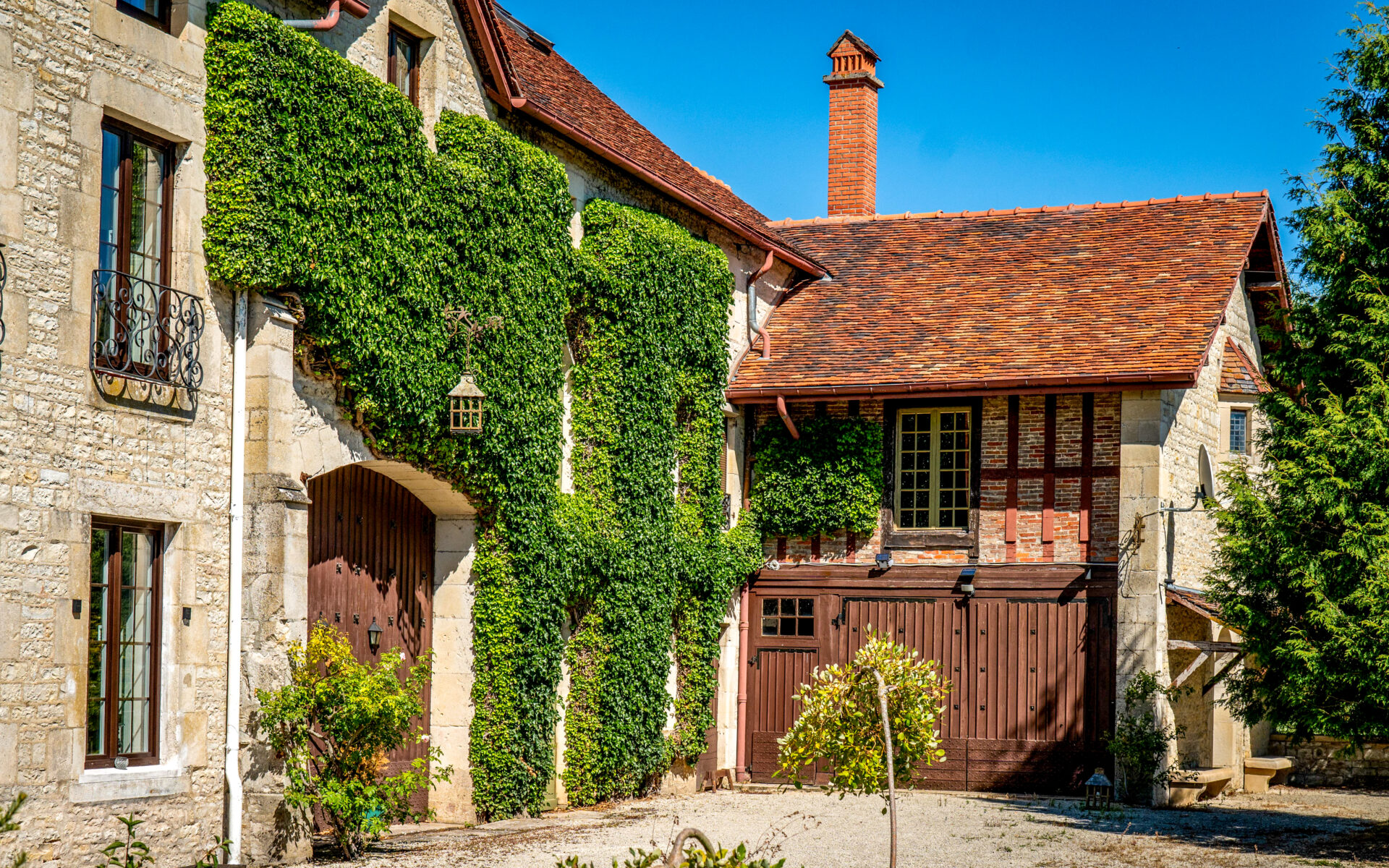 Bâtisse ancienne en pierre avec toiture en tuiles et galerie en bois