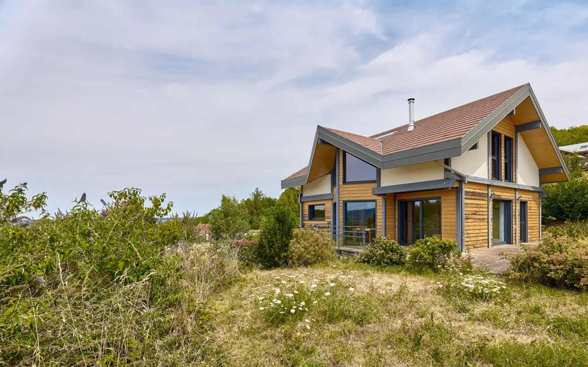 Façade et verdure de la maison contemporaine sur les hauteurs de Besançon à vendre - Arrière-Cour, agence immobilière spécialisée dans le Doubs